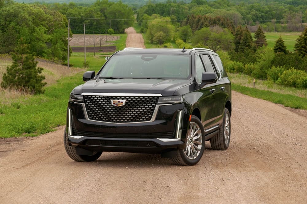 A parked black 2021 Cadillac Escalade on a dirt road