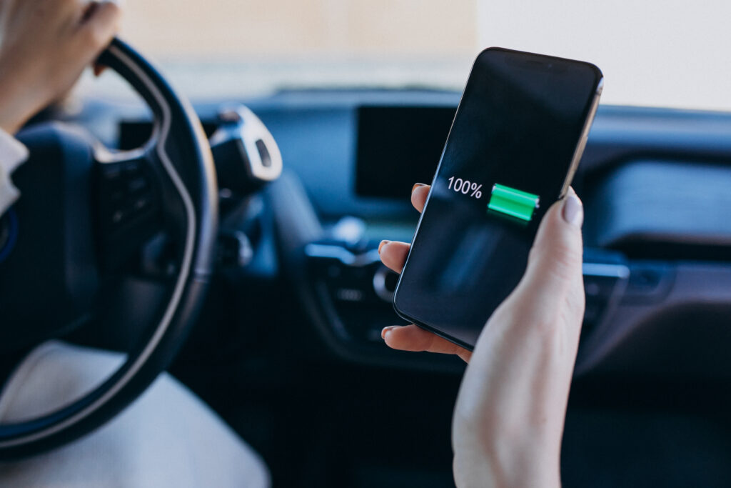 Woman charging phone inside her car