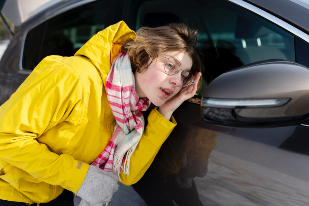 Woman listening to strange noises coming from her car