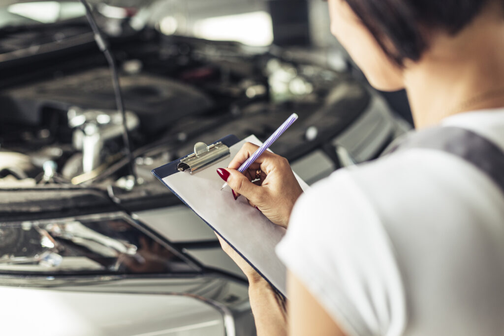 woman checking car for maintenance